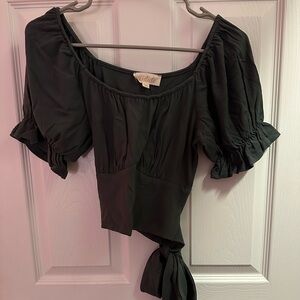 Green crop top with ruffle sleeves and wrap waist.